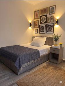 a bedroom with a bed with framed pictures on the wall at Park Plaza Haven in Cairo