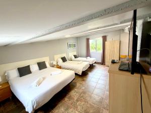 a hotel room with two beds and a flat screen tv at Mas de la Maria in Cambrils