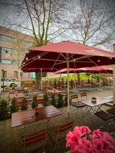 a patio with tables and umbrellas and pink flowers at Heimatblick Fulda in Fulda