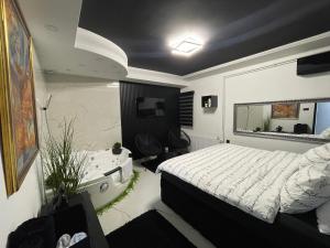 a bedroom with a bed and a bathroom with a sink at Tina apartman in Vranje