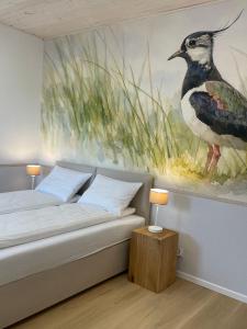 a bedroom with a bird painting on the wall at Dom Gościnny Zakole in Buda Ruska
