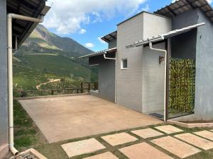a house with a patio with a view of a mountain at CORAÇÃO DO ALTO CHALES Hidromassagem in Caparaó Velho