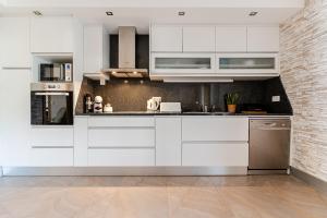 a kitchen with white cabinets and stainless steel appliances at Casa entre Rios in Alpendurada