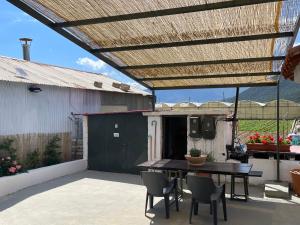 a patio with a table and chairs under a pergola at Madou house in Leonidio