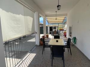 a dining room with a table and chairs on a balcony at Madou house in Leonidio +6 photos