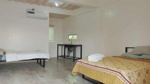 a white room with two beds and a table at Hidalgo Lodge in Santa Ana