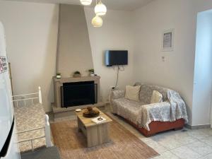 a living room with a couch and a tv at Madou house in Leonidio