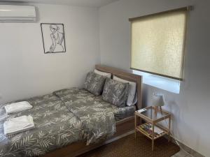 a small bedroom with a bed and a window at Madou house in Leonidio