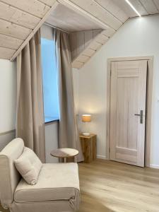 a living room with a white couch and a window at Dom Gościnny Zakole in Buda Ruska