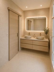 a bathroom with two sinks and a mirror at Bienvenue au soleil in Sainte-Marie-la-Mer