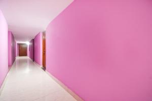 a hallway with purple walls and a white floor at Hotel O The Shivansh Inn in Chandanpur