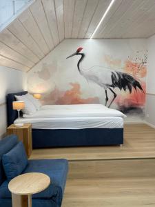 a bedroom with a bed with a bird on the wall at Dom Gościnny Zakole in Buda Ruska