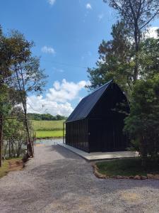 a large black building with a field in the background at Verde Vale in Nova Petrópolis