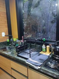 a kitchen counter with a sink and a window at Verde Vale in Nova Petrópolis +34 photos
