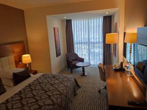 a hotel room with a bed and a desk and a chair at Crixus Hotels Duhok in Duhok +7 photos