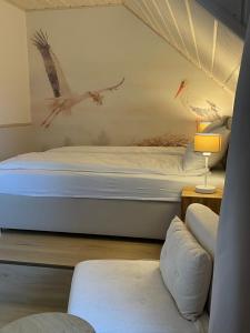 a bedroom with a bed with birds on the wall at Dom Gościnny Zakole in Buda Ruska