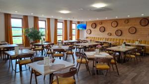 a restaurant with tables and chairs and windows at Wellness Penzión Vínny Dom in Streda nad Bodrogom