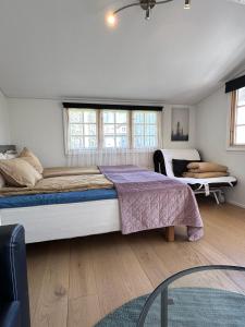a bedroom with a large bed and two windows at Mysig stuga i lugnt villaområde med eget badrum och kök i huvudbyggnadens källare in Kalmar