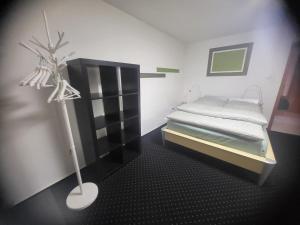 a small bedroom with a bed and a black cabinet at Über den Dächern von Furth im Wald in Furth im Wald