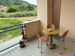 a balcony with a table and chairs and a window at Le Persiane Azzurre ovest in Albiano