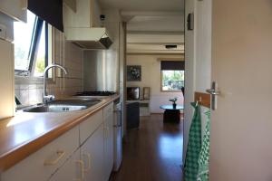 a kitchen with a sink and a stove at 't Veldhuisje 110 - naast het bos, honden toegestaan in Anloo