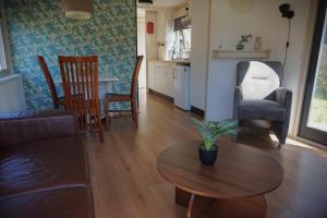 a living room with a table and chairs and a kitchen at 't Veldhuisje 110 - naast het bos, honden toegestaan in Anloo +14 photos