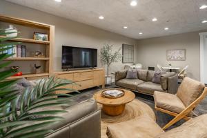 a living room with a couch and a tv at La Residence Suite Hotel in Bellevue