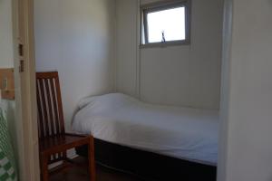 a small bedroom with a bed and a window at 't Veldhuisje 110 - naast het bos, honden toegestaan in Anloo