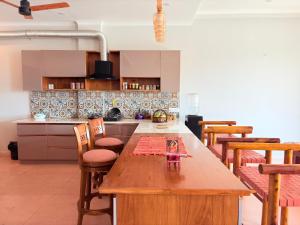 a large kitchen with a wooden table and chairs at Eternal Bliss By Ganga Blessing in Rishīkesh
