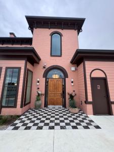 a pink house with a checkered floor and a wooden door at Salt Ranch Hotel in Nashville