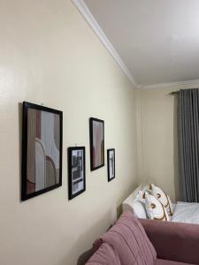 a bedroom with three pictures on the wall and a bed at Ruaka Karington Studio in Ruaka