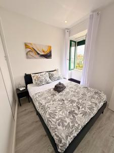a bedroom with a bed with a gray and white comforter at Naval - Marina View Apartments in Vila do Conde