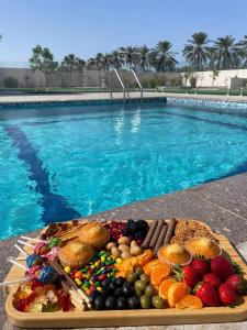 a tray of food next to a swimming pool at Rovana Chalet in Barka