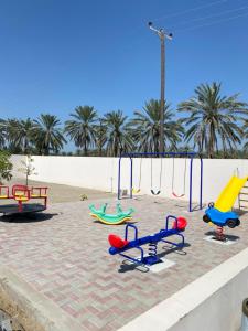 a playground with colorful play equipment on the beach at Rovana Chalet in Barka