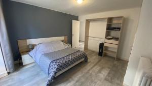 a bedroom with a bed with a blue wall at Maison typique auvergnate in Saint-Jacques-des-Blats +25 photos