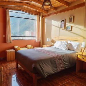 a bedroom with a large bed and a window at Sunshine in Ollantaytambo