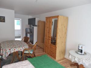 a living room with a table and a wooden cabinet at Ferienwohnung Pasewalk Zentrum in Pasewalk