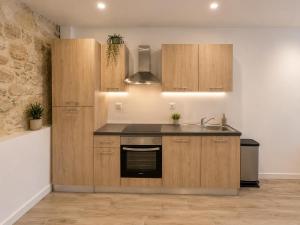 a kitchen with wooden cabinets and a sink at Maison moderne 3 chambres avec terrasse Maison Familiale Région Bordeaux in Salleboeuf
