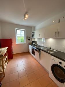 a kitchen with white cabinets and a sink at Apartment am Paradiespark in Jena