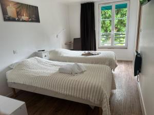 a bedroom with two beds and a window at Le Rhum Antik in Puybrun