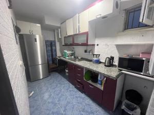 a kitchen with purple cabinets and a stainless steel refrigerator at AirPort geust house in Arnavutköy