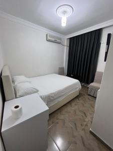 a bedroom with a bed and a table and a window at AirPort geust house in Arnavutköy