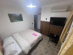 a small bedroom with a bed and a flat screen tv at AirPort geust house in Arnavutköy