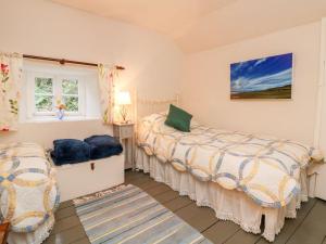 a bedroom with two beds and a window at Whitefield Cottage in Barnstaple