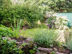 a garden with a pond with flowers and a fence at Whitefield Cottage in Barnstaple