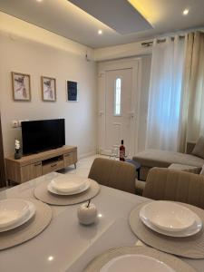 a living room with a table and a television at Studio AZOTI in Kástron