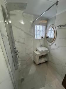 a bathroom with a shower with a sink and a mirror at Studio AZOTI in Kástron +21 photos
