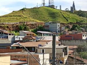 a city with houses and a hill with vines at Pousada Rota da Luz in Aparecida