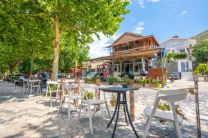 a group of tables and chairs in front of a building at Shiroka Stays in Shirokë