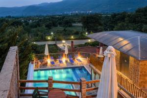 a swimming pool with an umbrella on a building at Hotel Athina in Kato Loutraki